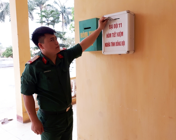 Chiến sĩ tự nguyện góp tiền lẻ vào hòm tiết kiệm sau khi nhận phụ cấp.